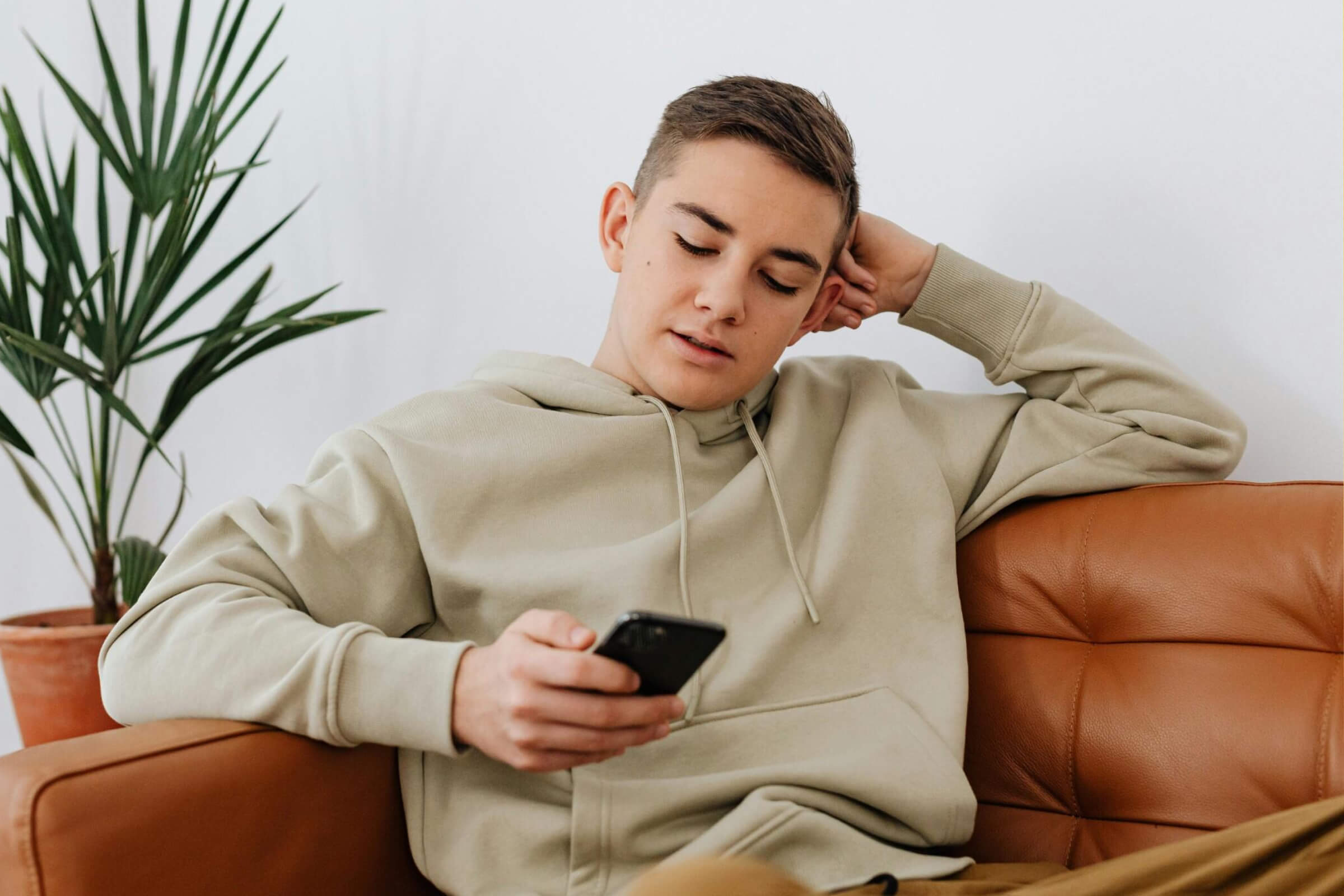 boy sitting on a couch on his phone